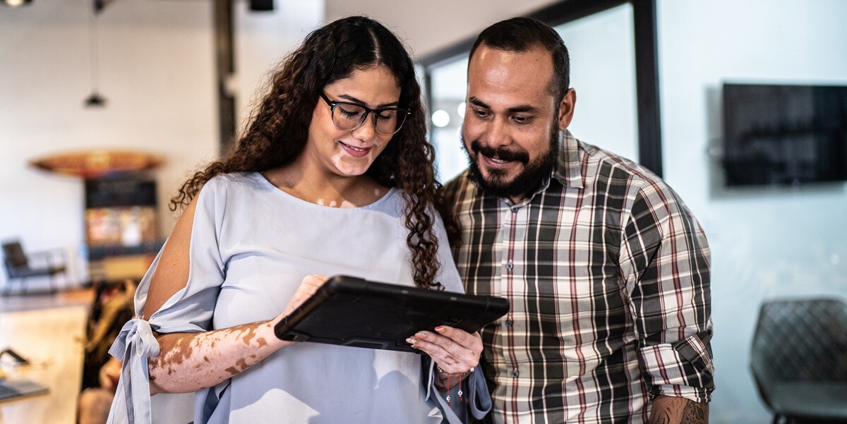 two people in the office reviewing a tablet