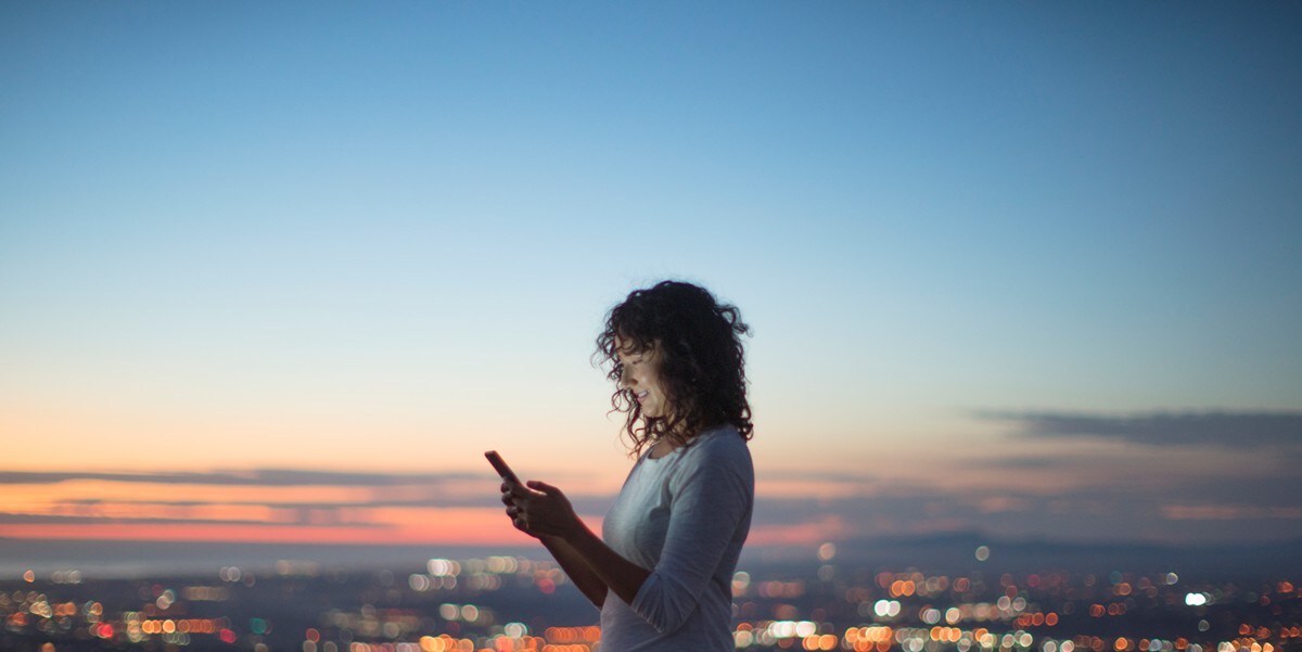 woman using cellphone, standing outside