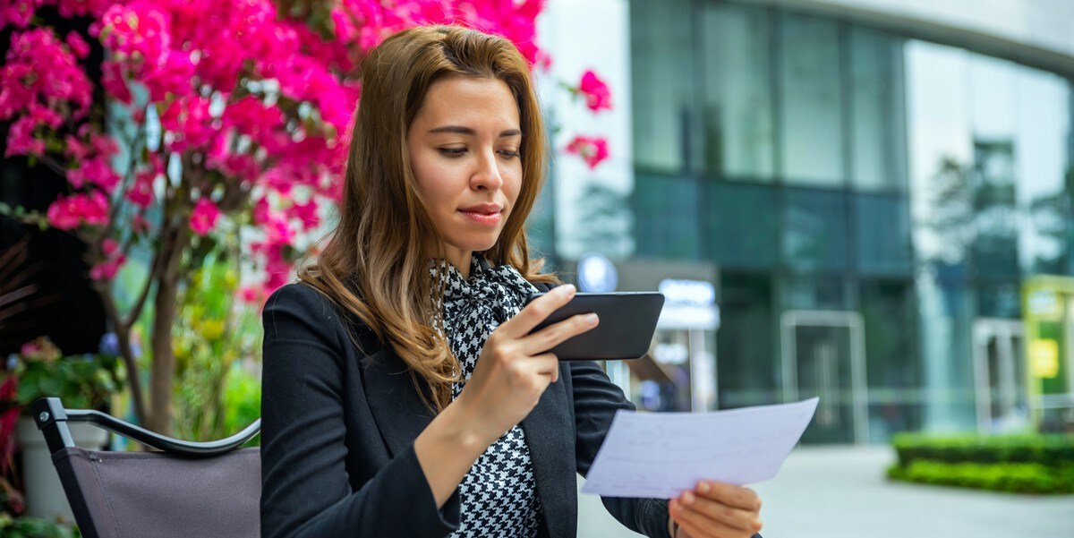 woman scanning receipt, seated outside