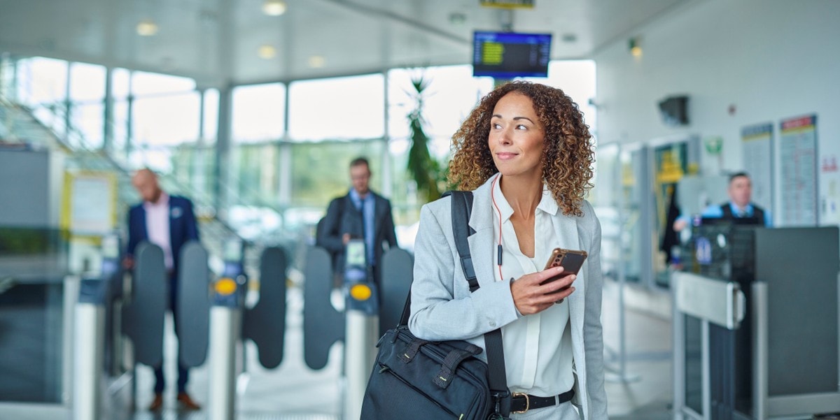 traveler in airport, holding cellphone
