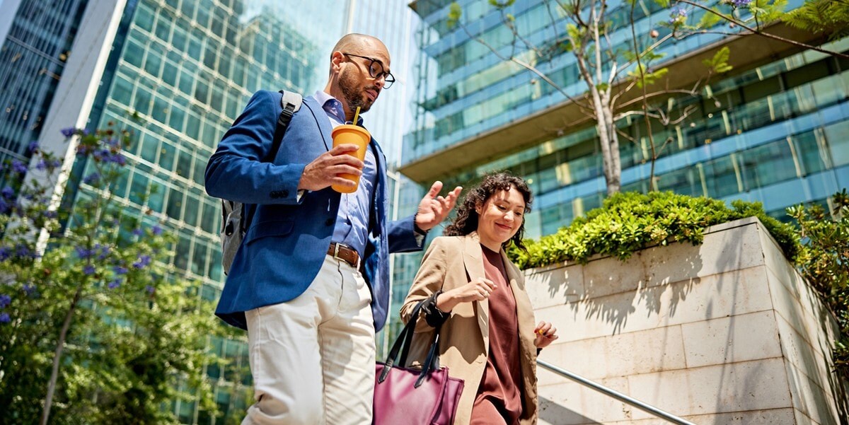 two professionals walking down stairs, outside of office building