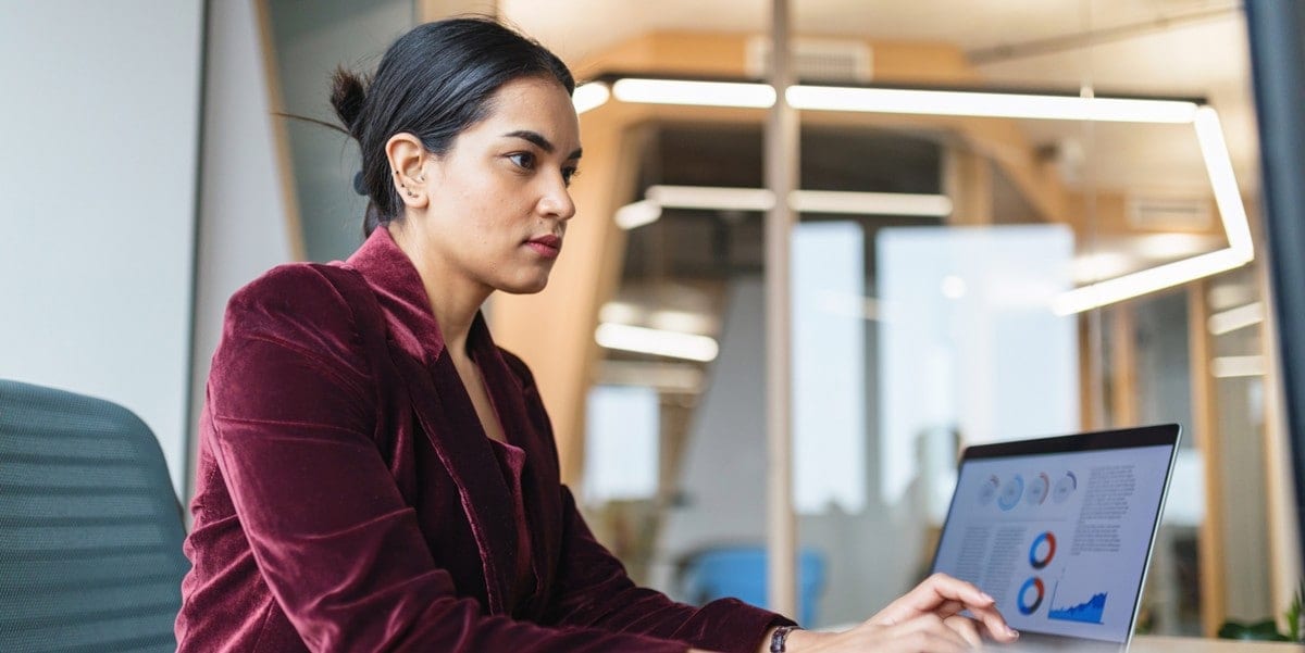 professional woman working at desk with laptop