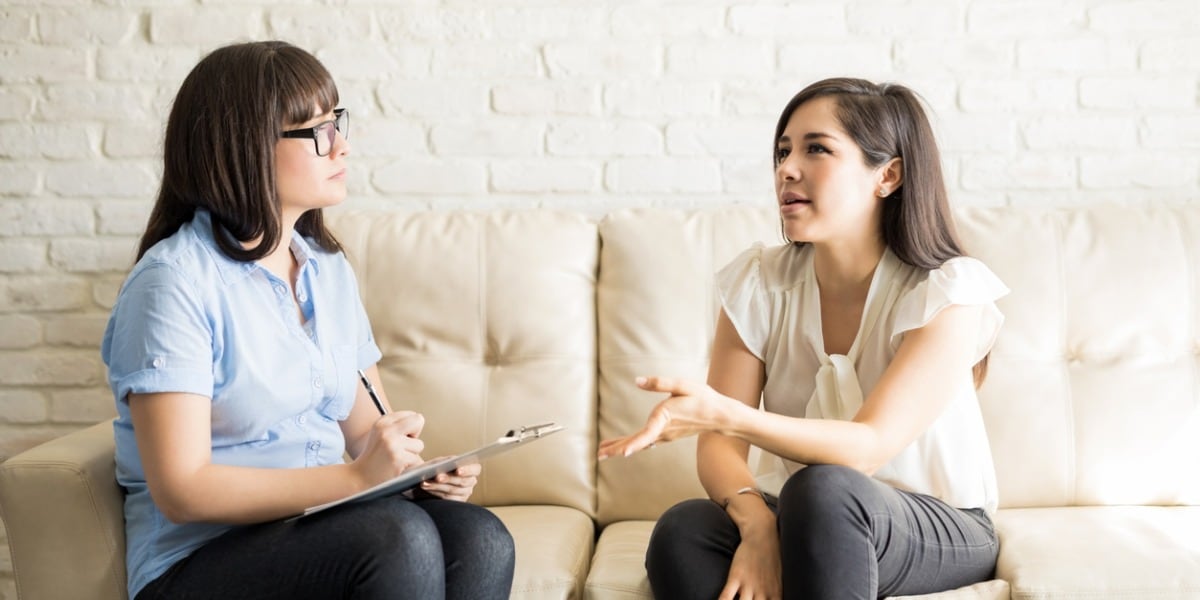 two women sitting on a couch