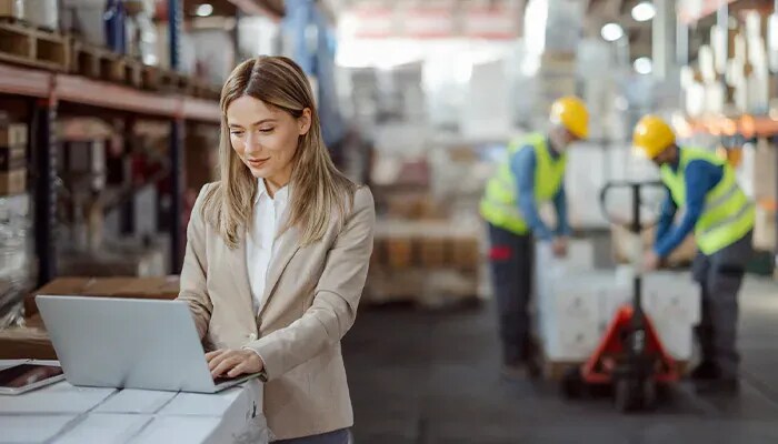 woman working on laptop in warehouse